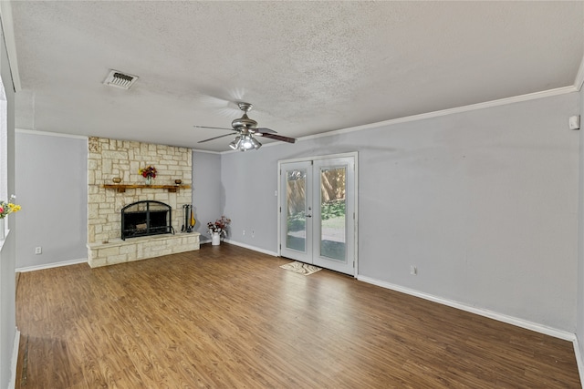 unfurnished living room featuring crown molding, hardwood / wood-style flooring, ceiling fan, a fireplace, and a textured ceiling