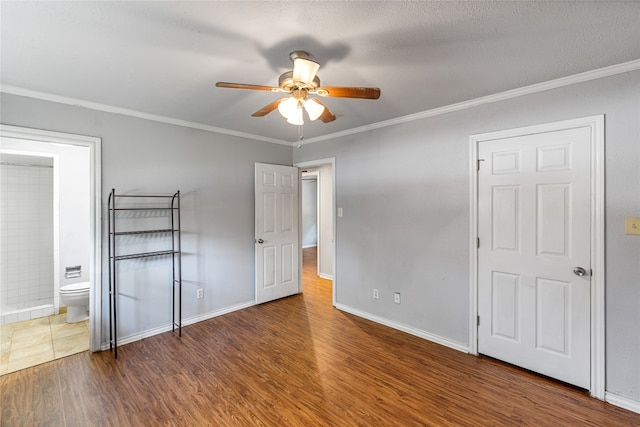 unfurnished bedroom with dark wood-type flooring, crown molding, ceiling fan, a textured ceiling, and connected bathroom