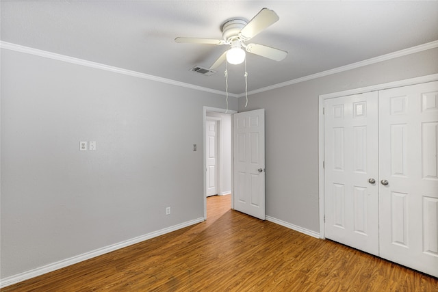 unfurnished bedroom featuring ceiling fan, hardwood / wood-style floors, and crown molding