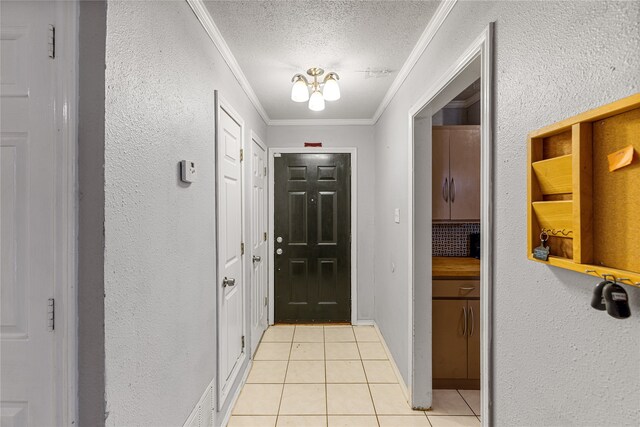 doorway to outside with light tile patterned floors, a textured ceiling, and ornamental molding