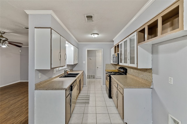 kitchen with sink, ornamental molding, appliances with stainless steel finishes, light tile patterned flooring, and white cabinetry