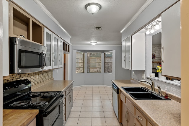 kitchen featuring sink, light tile patterned flooring, ornamental molding, and appliances with stainless steel finishes