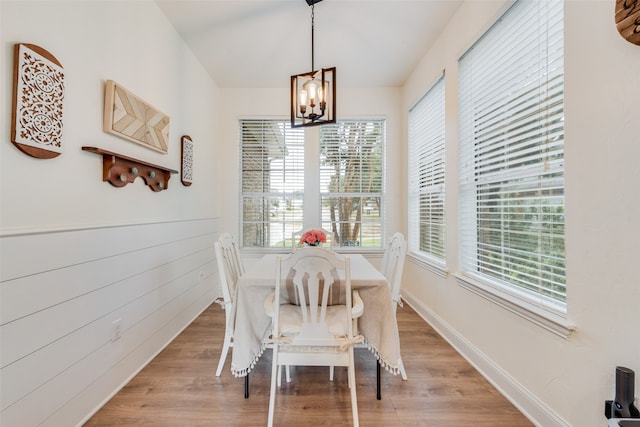 dining room with light wood-type flooring, an inviting chandelier, and a healthy amount of sunlight