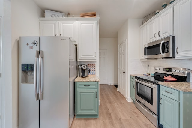 kitchen featuring white cabinetry, light stone countertops, decorative backsplash, appliances with stainless steel finishes, and light hardwood / wood-style floors