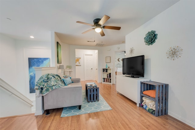 living room featuring ceiling fan and light hardwood / wood-style floors