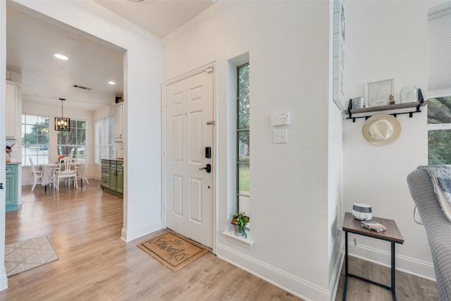 entryway featuring a notable chandelier and light hardwood / wood-style floors