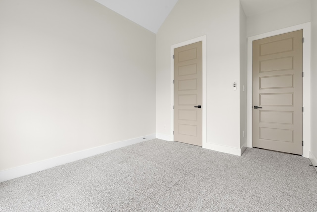 unfurnished bedroom with lofted ceiling and carpet