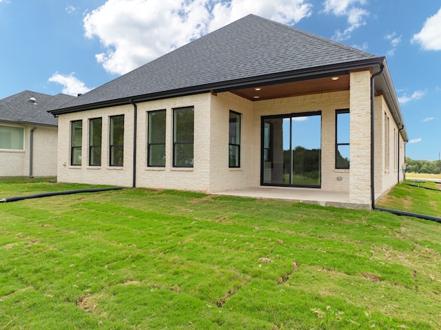 rear view of property featuring a yard and a patio area