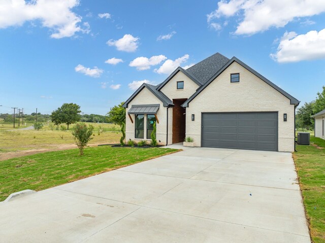 view of front of property featuring a front lawn and central AC