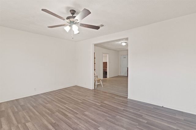 spare room with a textured ceiling, hardwood / wood-style flooring, and ceiling fan