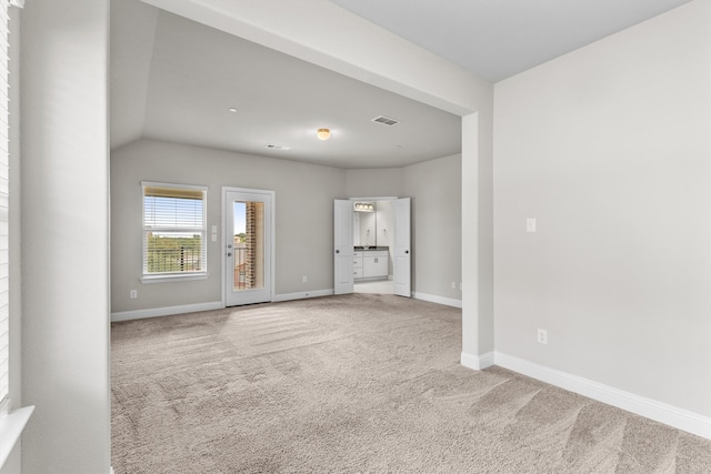 unfurnished living room with carpet flooring and vaulted ceiling