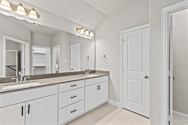 bathroom featuring tile patterned flooring, vanity, and vaulted ceiling