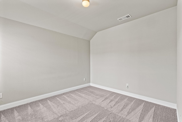 spare room featuring lofted ceiling and carpet