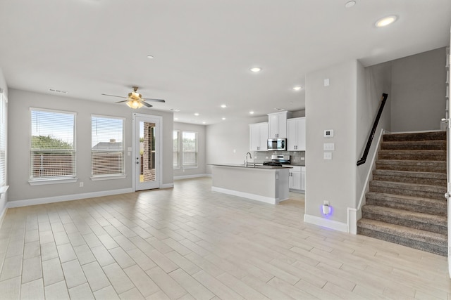 unfurnished living room with a healthy amount of sunlight, light hardwood / wood-style flooring, and ceiling fan