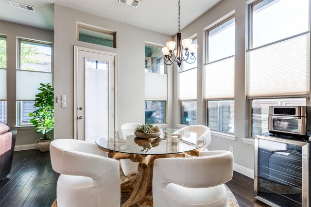 dining room with dark wood-type flooring, an inviting chandelier, and beverage cooler