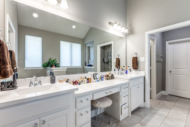 bathroom featuring vanity, vaulted ceiling, tile patterned flooring, and walk in shower