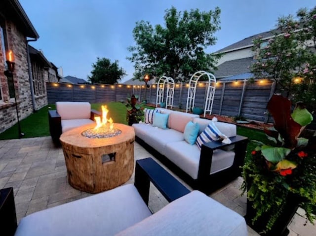 patio terrace at dusk with an outdoor living space with a fire pit