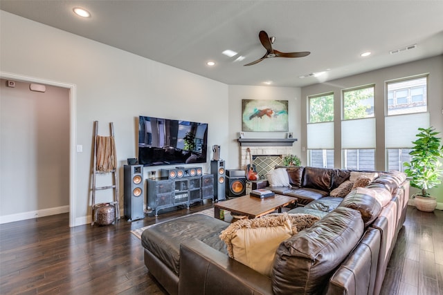 living room with dark wood-type flooring, a fireplace, and ceiling fan