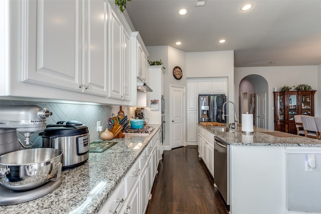 kitchen featuring a center island with sink, appliances with stainless steel finishes, white cabinetry, dark hardwood / wood-style floors, and sink