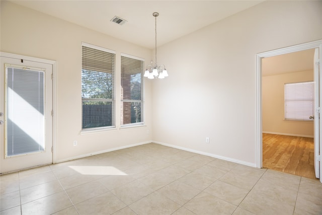 unfurnished dining area with a notable chandelier and light wood-type flooring