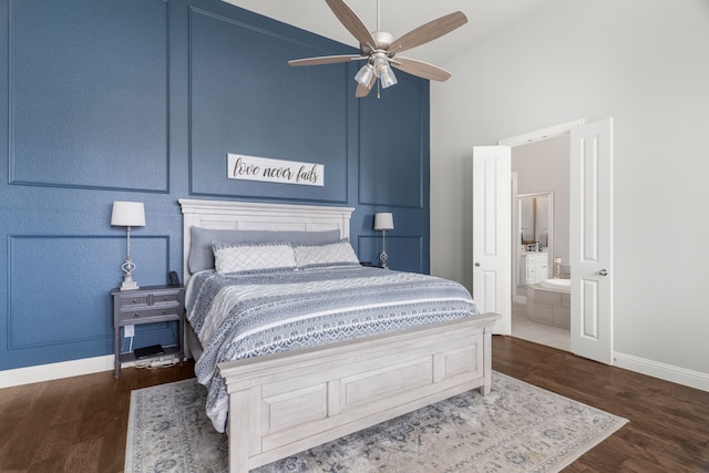 bedroom featuring ceiling fan, vaulted ceiling, dark hardwood / wood-style flooring, and ensuite bath