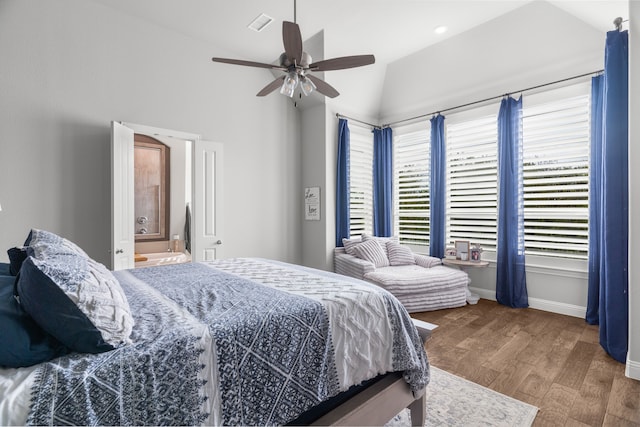 bedroom with lofted ceiling, ceiling fan, hardwood / wood-style floors, and ensuite bath