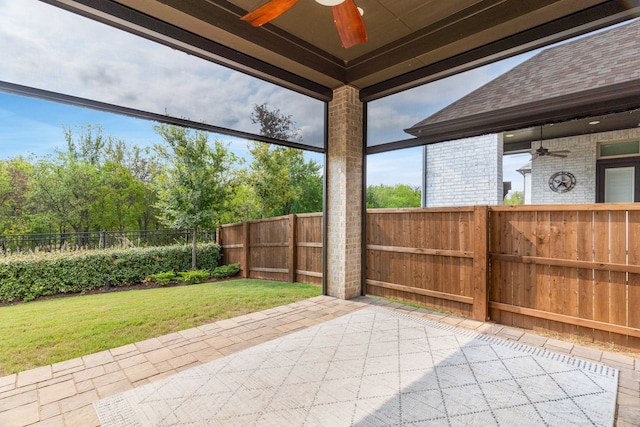 unfurnished sunroom with ceiling fan