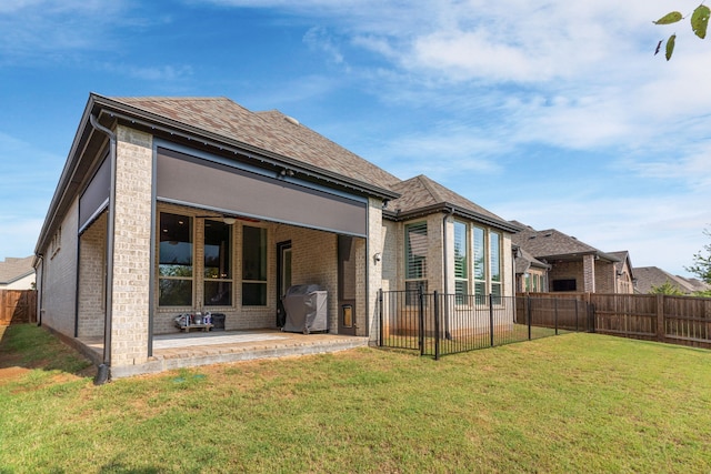 back of house with a lawn and a patio area