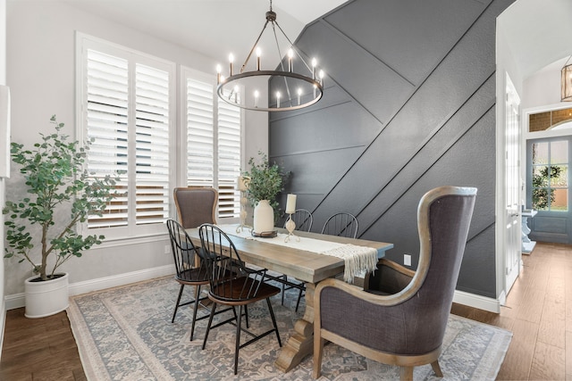 home office with dark wood-type flooring and a notable chandelier