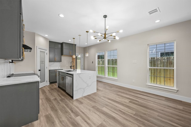 kitchen featuring pendant lighting, sink, wood-type flooring, a kitchen island with sink, and dishwasher