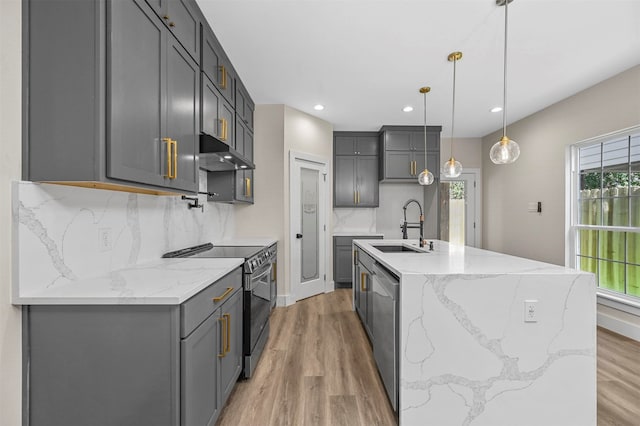 kitchen featuring pendant lighting, sink, hardwood / wood-style flooring, stainless steel appliances, and gray cabinets