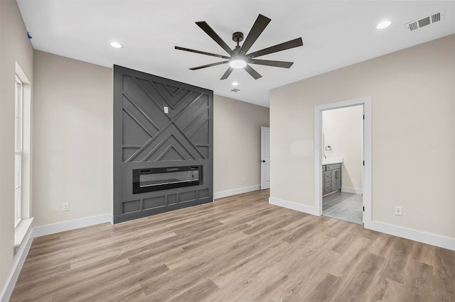 unfurnished living room with ceiling fan and light wood-type flooring