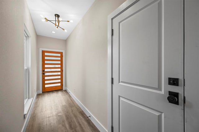 entryway featuring a notable chandelier and wood-type flooring