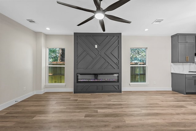 unfurnished living room featuring ceiling fan and light hardwood / wood-style flooring