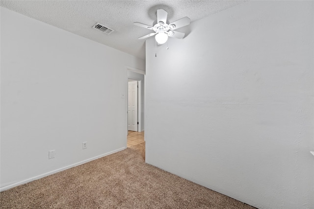 carpeted spare room with a textured ceiling and ceiling fan