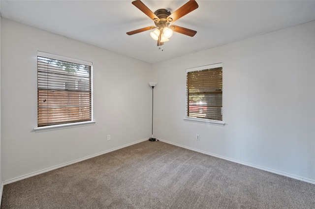 carpeted spare room featuring ceiling fan