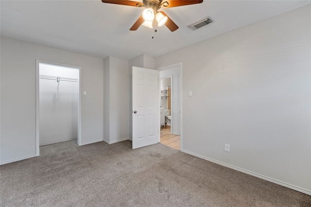 unfurnished bedroom with ceiling fan, light colored carpet, and a closet