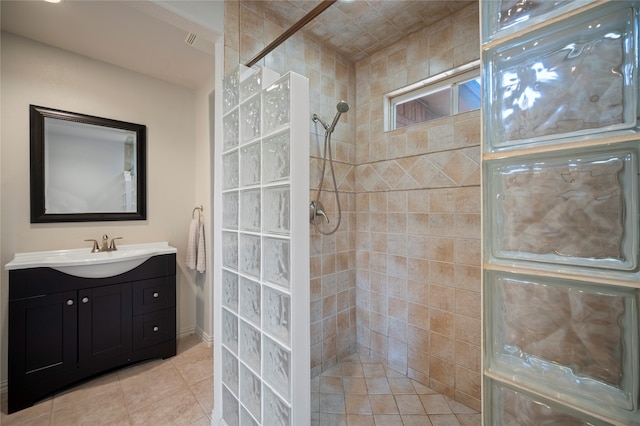 bathroom featuring tile patterned flooring, vanity, and tiled shower