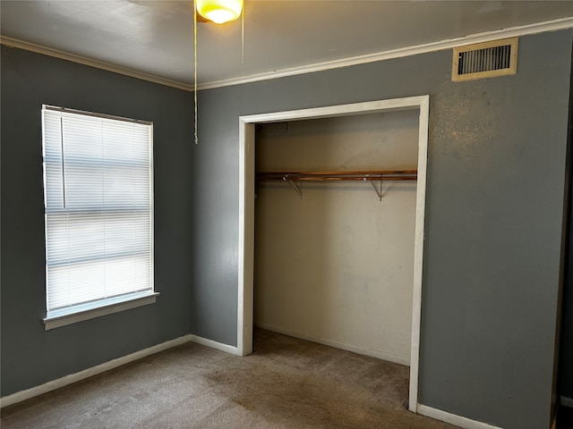 unfurnished bedroom with a closet, carpet flooring, and ornamental molding