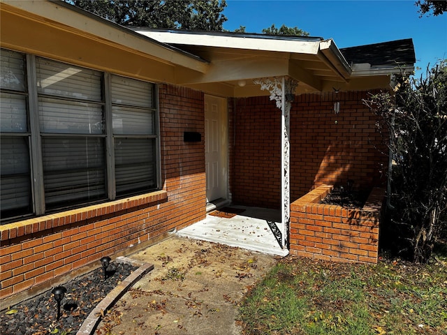 view of exterior entry with brick siding