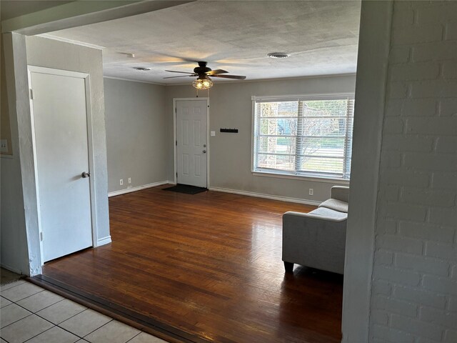 interior space featuring ornamental molding, a textured ceiling, wood-type flooring, and ceiling fan