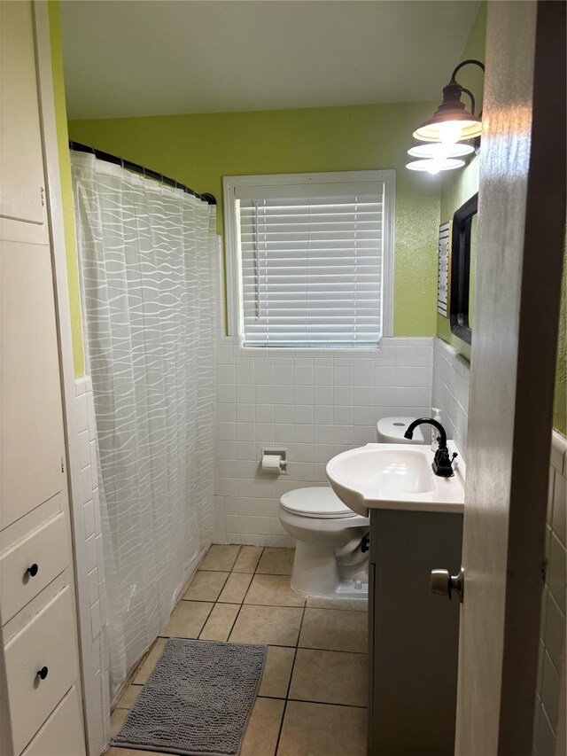 bathroom with toilet, tile patterned floors, vanity, tile walls, and a shower with curtain