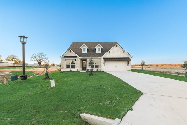 view of front of home with a front yard and a garage