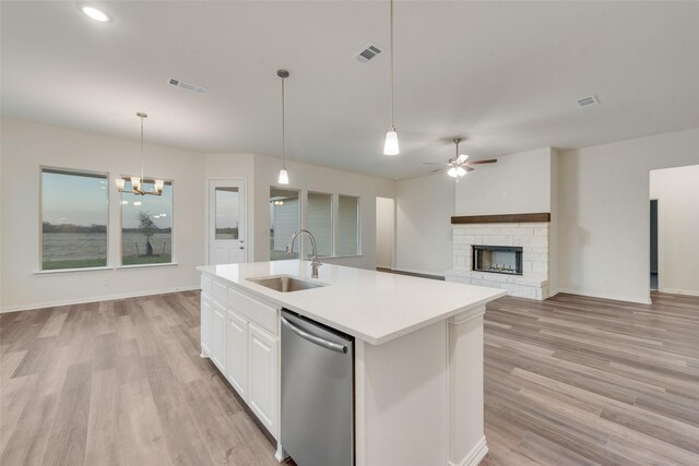 kitchen with sink, white cabinets, stainless steel dishwasher, and light wood-type flooring