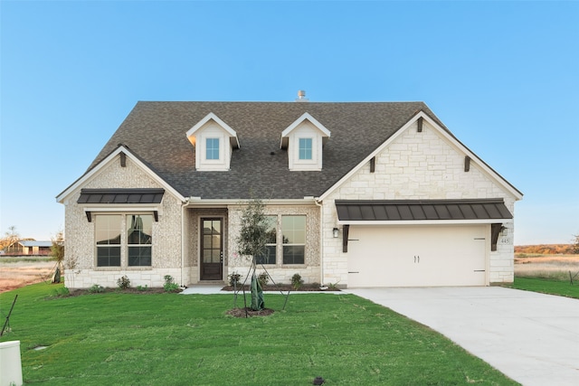 view of front of home with a front lawn and a garage