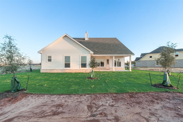 rear view of house featuring a yard