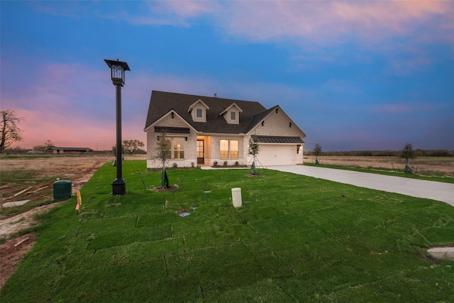 view of front of home with a yard and a garage