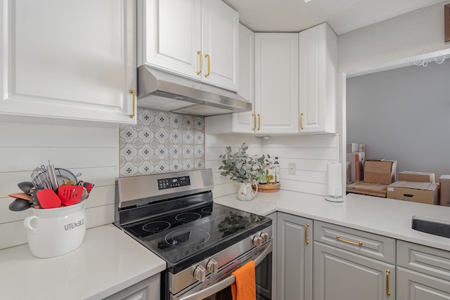 kitchen featuring white cabinets, tasteful backsplash, and electric stove