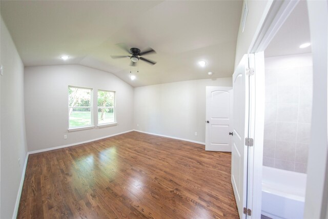 empty room with ceiling fan, lofted ceiling, and dark wood-type flooring