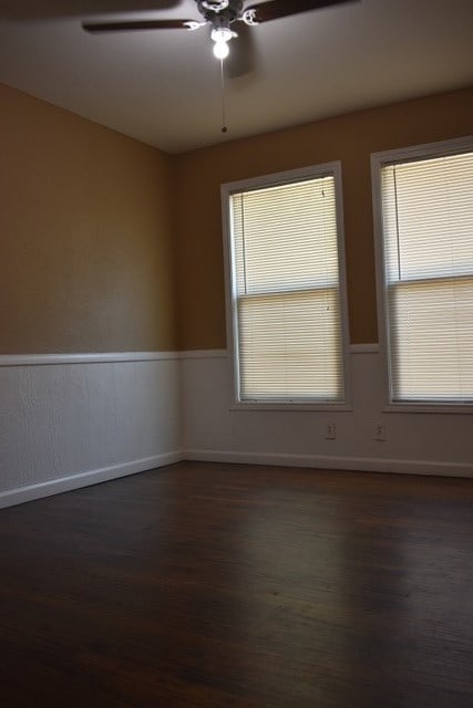 empty room with dark hardwood / wood-style flooring and ceiling fan